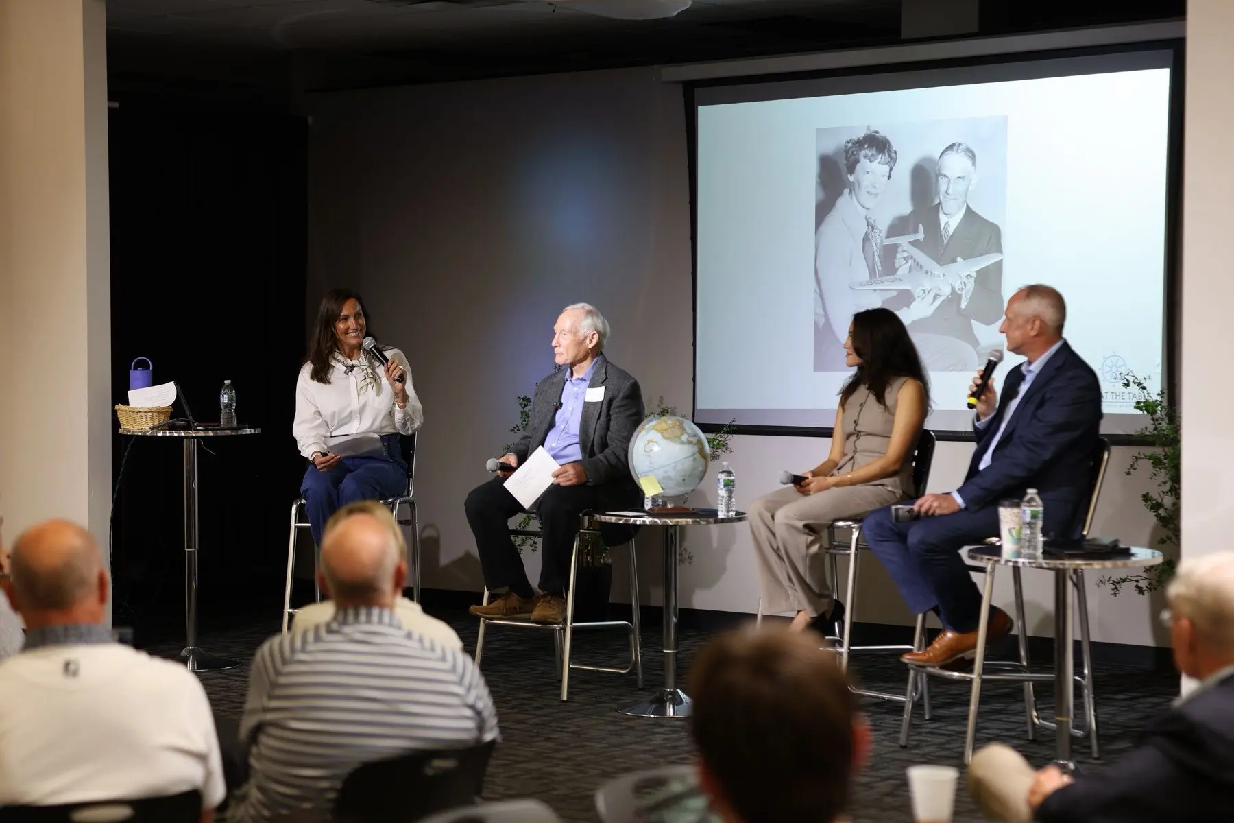 The panel on stage at Launch Fishers, with guests seated in front of them