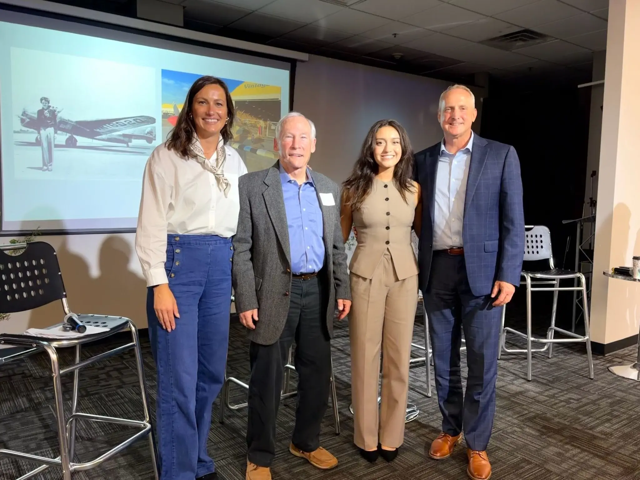 The four people on stage, standing together after the conversation